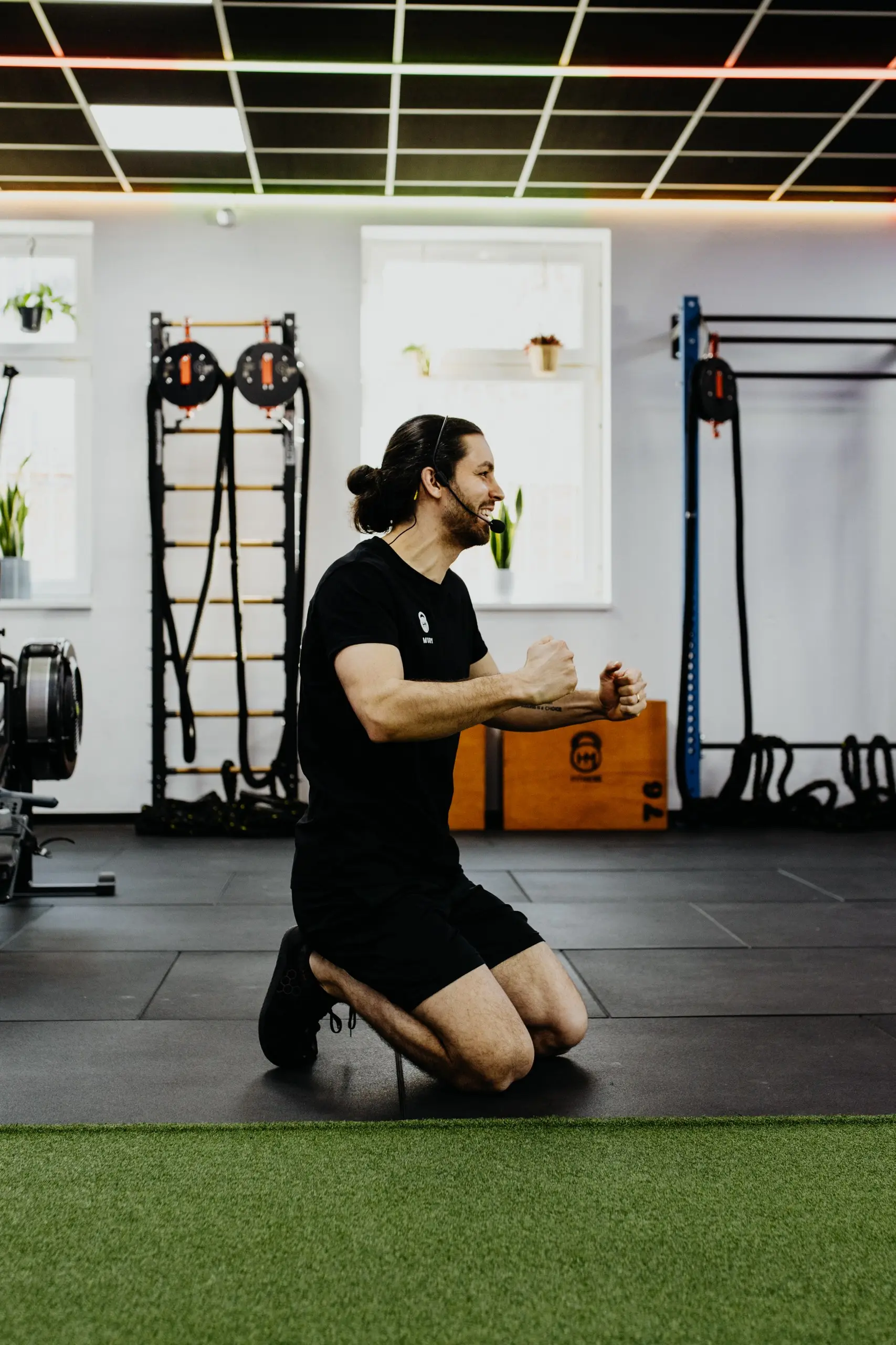 Coach Mury kniet auf der Trainingsfläche und erklärt eine Übung